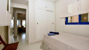 a white bedroom with a bed and a chair at Apartamento Punta Glea in Orihuela Costa +19 photos