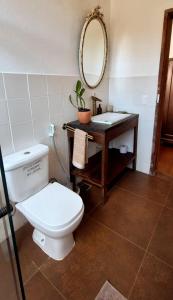 a bathroom with a toilet and a sink with a mirror at Casa Miralago in Santana do Riacho
