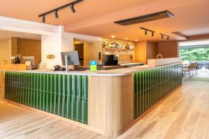 a bar in a restaurant with a green counter at Sure Hotel by Best Western Tours Sud in Chambray-lès-Tours +30 photos