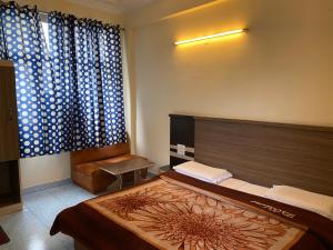 a bedroom with a large bed and a window at AASHIRWAD HOTEL in Katra