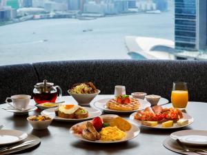 a table with plates of food on a table with a view at Upper House Hong Kong in Hong Kong
