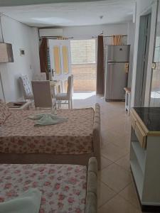 エル・アラメインにある3B basement Chalet 4beds 2 bed rooms with pool view114 green beachのベッド2台付きの部屋、冷蔵庫付きのキッチンが備わる客室です。