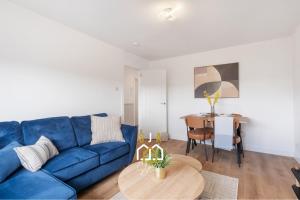 a living room with a blue couch and a table at Braehead Stay - SJA Stays - Modern 2 Bed House in Cruden Bay