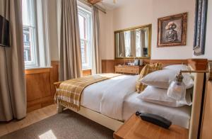 a bedroom with a large bed and a mirror at The Old Farmhouse Pub and Rooms in London