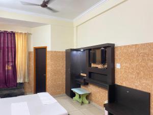 a room with a bed and a flat screen tv at AASHIRWAD HOTEL in Katra