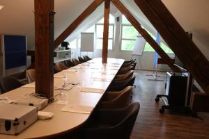 uma mesa longa numa sala com cadeiras e uma mesa em Hotel Mühle em Binzen