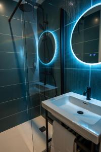 un baño con lavabo y espejo en la Game Room, en Pau