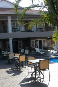 a patio with tables and chairs next to a pool at Presidential Superior Room in Durban