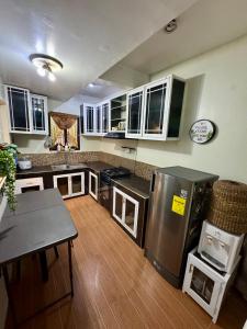 a kitchen with a stainless steel refrigerator and a table at M & D Rentals by Jick in Butuan +13 photos