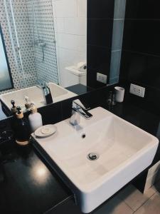 a bathroom with a white sink and a mirror at Светлые апартаменты Royal Lee in Ban Bo Han