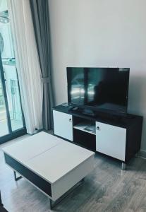 a living room with a flat screen tv and a coffee table at Светлые апартаменты Royal Lee in Ban Bo Han