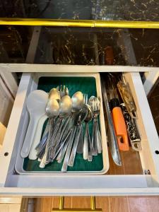 a drawer filled with silver utensils on a shelf at M & D Rentals by Jick in Butuan