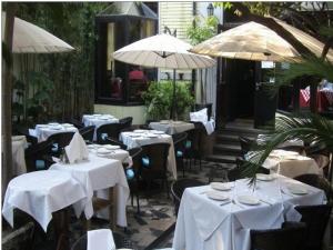 restauracja z białymi stołami, krzesłami i parasolami w obiekcie Kevin's Old House w Szanghaju