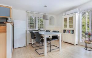 a kitchen with a table and chairs and a refrigerator at 2 Bedroom Beautiful Home In Erm in Erm