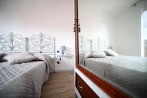 サルザーナにあるB&B Agorà Sarzanaのベッドルーム1室(隣り合わせのベッド2台付)