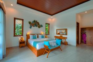 a bedroom with a bed and a table and a chair at Matahari Lumbung Resort in Ubud +28 photos
