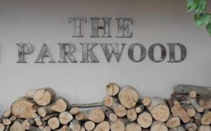a sign that reads the parhy wood next to logs at The Parkwood in Johannesburg