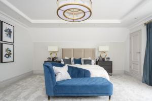 a bedroom with a blue couch in front of a bed at Luxury 3 Bed Penthouse with Large Terrace and Private Parking in Sunningdale