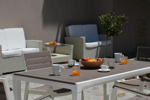 a white table with a bowl of oranges on it at Troia Resort Luxury Studios in Asprovalta