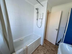 a bathroom with a bath tub and a sink at 5 Berth Chalet To Hire In Hemsby Near Hemsby Beach Ref 18117B in Hemsby +8 photos