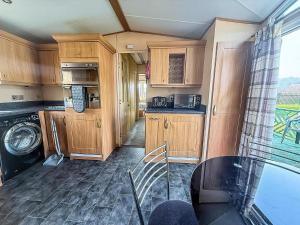 a kitchen with wooden cabinets and a glass table at Great 4 Berth Caravan For Hire In Suffolk At North Denes, Ref 40149Nd in Lowestoft +9 photos