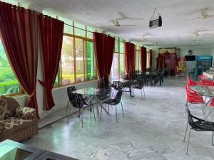 a room with tables and chairs and red curtains at lake view hotel and resort in Khānpur