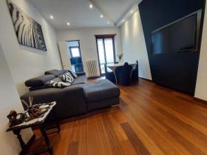 a living room with a couch and a flat screen tv at ATTICO LUX LE GRU in Grugliasco