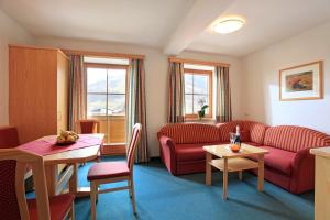 a living room with a couch and a table at Schneeberghof in Westendorf