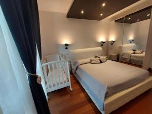 a bedroom with a crib and a mirror at ATTICO LUX LE GRU in Grugliasco