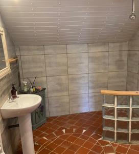 bagno con lavandino bianco e pavimento piastrellato di Sunflower Cottage a Genneteil