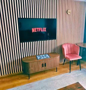 a living room with a tv and a table and a chair at Willa przy Krupówkach in Zakopane