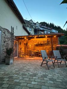 a patio with two chairs and a table and a building at Ferienhaus am Schloß in Malberg