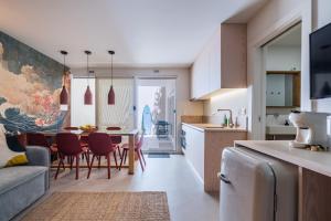 een keuken en woonkamer met een tafel en stoelen bij Chalet Lídia Lodges in Estoril