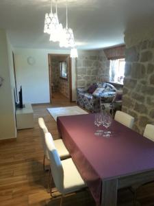 a dining room with a table and chairs and a living room at Apartment Peky in Rab