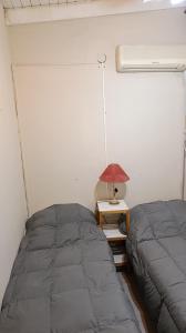 a bedroom with a bed and a table with a lamp at Apart POTRERILLO in San Fernando del Valle de Catamarca