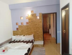 a bedroom with a bed and a brick wall at Samaya in Agigea