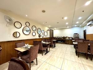 a restaurant with tables and chairs and mirrors on the wall at Hotel Bahl Regency in Zirakpur