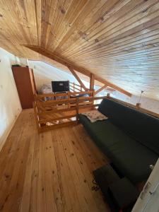 a living room with a couch and a wooden ceiling at Sac des Vertues Bordure Rivière in Beaumont-sur-Sarthe