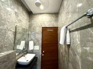 a bathroom with a sink and a mirror at Hotel Bahl Regency in Zirakpur +150 photos