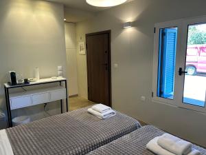 a bedroom with two beds and a desk and a window at Stone residence across Eiffel's Tower - Filiatro 2 in Filiatra