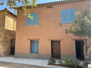 an orange building with blue shutters on it at Stone residence across Eiffel's Tower - Filiatro 2 in Filiatra