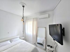 a bedroom with a tv and a bed and a mirror at VK's Downtown Suite in Chalkida