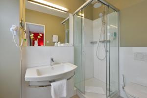 a bathroom with a sink and a shower at INVITE Hotel Fulda City Hauptbahnhof in Fulda
