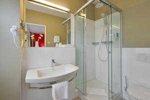 bagno con lavandino e doccia di INVITE Hotel Fulda City Hauptbahnhof a Fulda