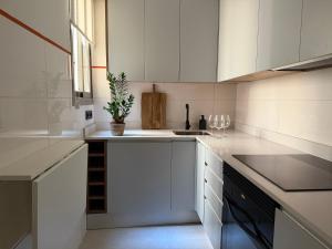 a kitchen with white cabinets and a plant on the counter at Sindical in Castellón de la Plana
