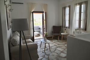 a living room with a couch and a chair at Rastoni Apartments Skiathos in Troulos