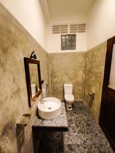 a bathroom with a sink and a toilet at Greenbliss Hiriketiya in Dickwella