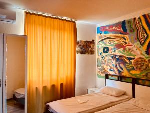 a bedroom with a bed and a painting on the wall at Green House in Kvareli