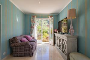 a living room with a chair and a window at Villa Soleil Riviera in Villefranche-sur-Mer