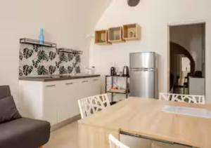 Una cocina con una mesa de madera y un refrigerador. en affitta camere fieramosca, en Barletta